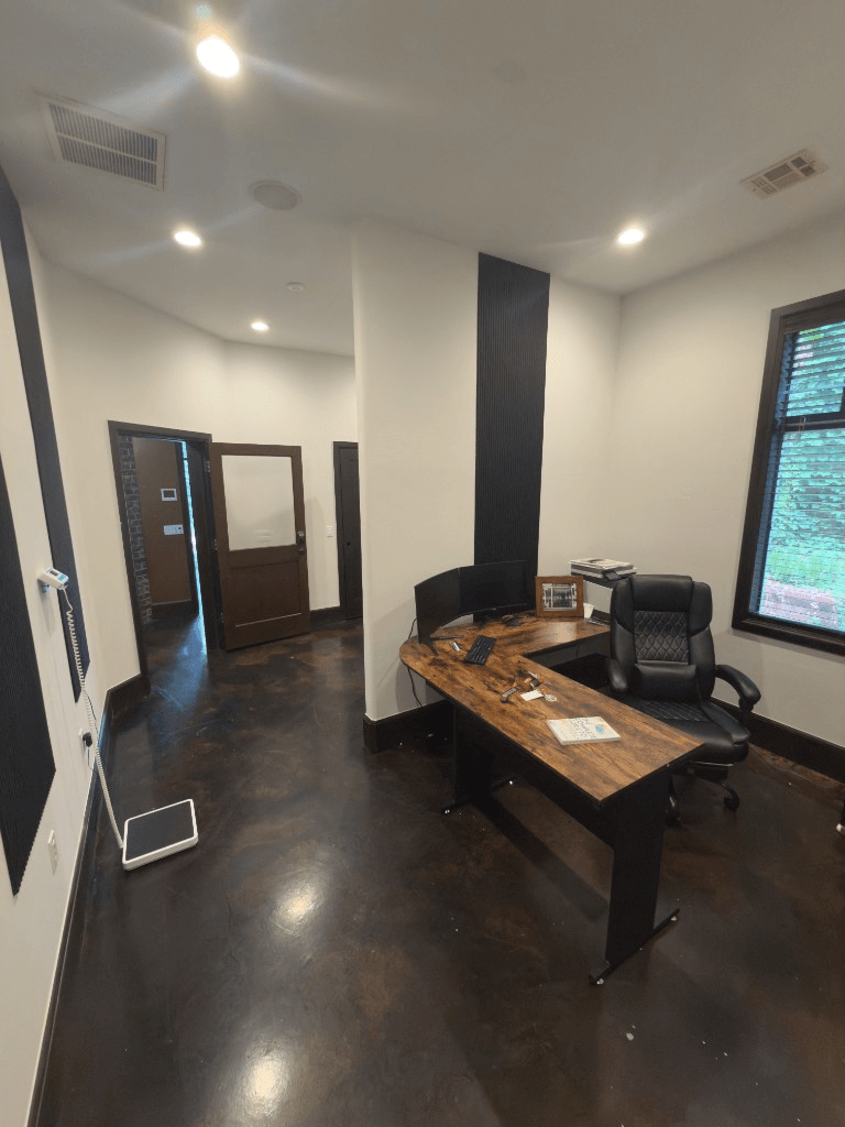 Consultation office at Oak & Sage Wellness Center in Edmond with a wood desk, monitors, and medical scale